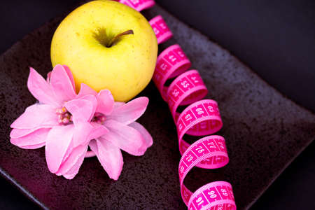 apple, flower, measuring tape as symbols of dietingの写真素材