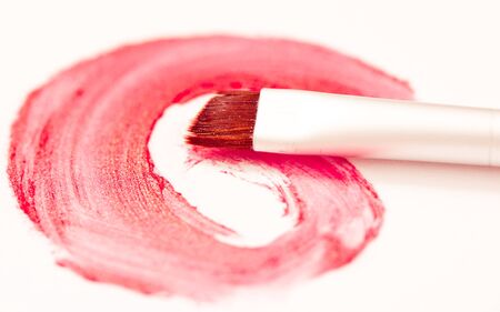 red lipstick stroke and makeup brush on whiteの写真素材