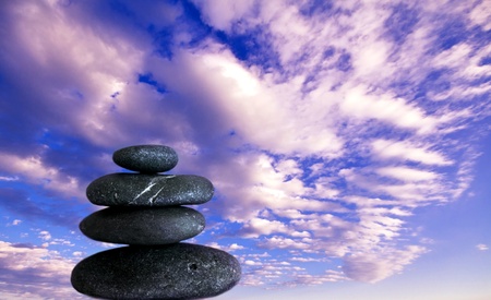 zen shot of balanced stones and a bright blue sky