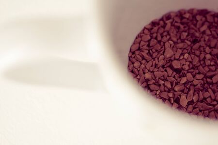 a cup with instant coffee on white