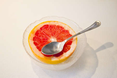 shot of a cup fruit  grapfruit in glass bowl over white tableの写真素材