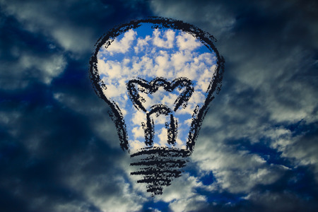 lighbulb with serene sky in the storm, symbol of creative business visions to overcome challengesの写真素材