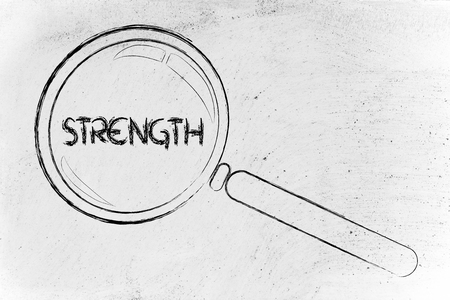 magnifying glass focusing on strenght, courage, determinationの写真素材