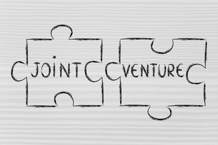 the words Joint Venture written on 2 matching pieces of a jigsaw puzzleの写真素材