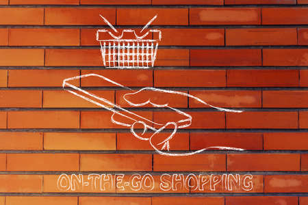 online shopping on the go, cart and hand holding a smartphoneの写真素材