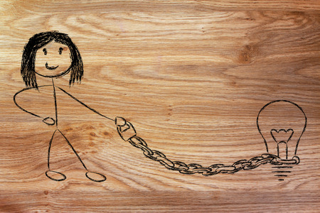 woman holding chained idea (lightbulb) on a leashの写真素材