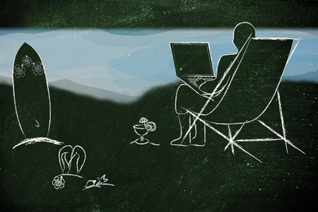 man typing on his laptop from the beachの写真素材