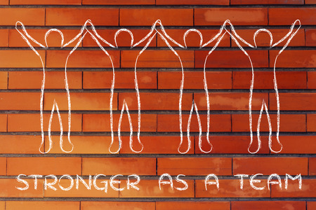stronger as a team: group of people standing together holding handsの写真素材