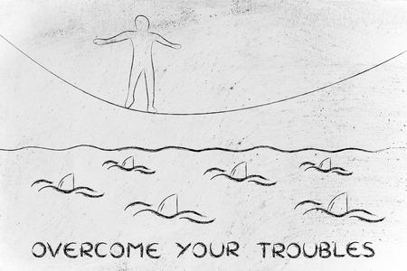 concept of overcoming your troubles: man on tightrope and sharks in the waterの写真素材