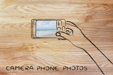 camera phone photos: person using smartphone to take a beach photoの写真素材