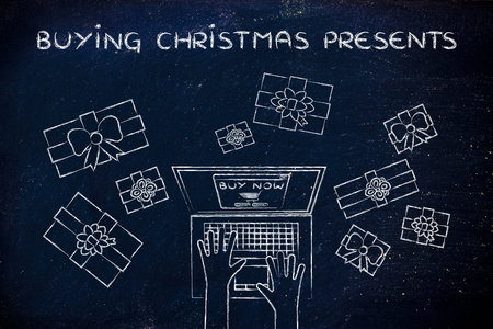 buying CHristmas presents: hands typing on computer to place an order, surrounded by giftsの写真素材