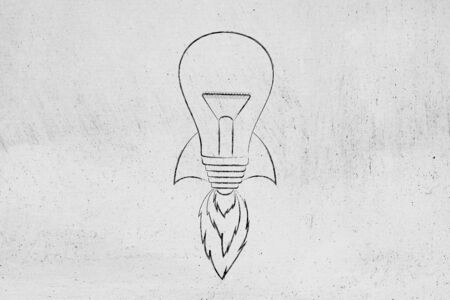 concept of launching a brilliant new idea: lightbulb with rocket set up