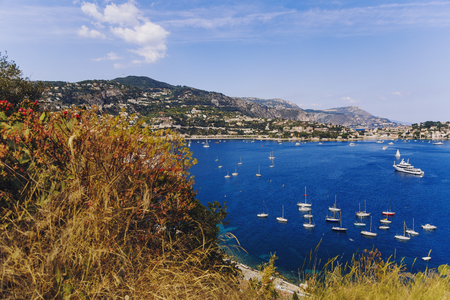 ViILLEFRENCHE-SUR-MER, FRANCE - 05 May, 2016: Villefranche seaside and coastline view from above the hillside, with deep blue water, serene sky and plenty of sailing boatsのeditorial素材