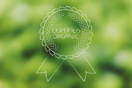 Certified organic badge over unfocused green salad bokeh backgroundの写真素材