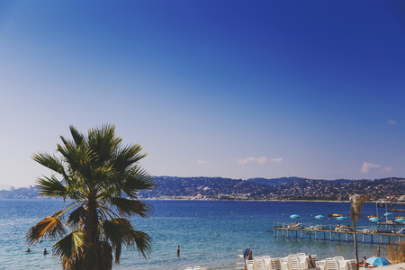 JUAN LES PINS, FRANCE - September 20th, 2016: Blue Mediterranean landscape and French beach with colorful umbrellas shot in Juan Les Pins on the French Rivieraのeditorial素材