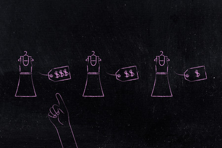 shopping choices concept: group of dresses with different price tags and hand pointing at the most expensive oneの写真素材