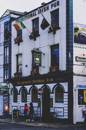 DUBLIN, IRELAND - July 15th , 2017: detail of a traditional Irish pub in the Temple Bar district in Dublin, Ireland right in front of the Ha'Penny bridge (with unidentified people)のeditorial素材
