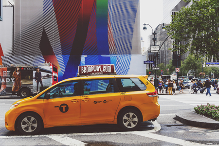 NEW YORK, NY - September 3rd, 2017: Yellow cab and unidentified people crossing the street in Midtown Manhattanのeditorial素材