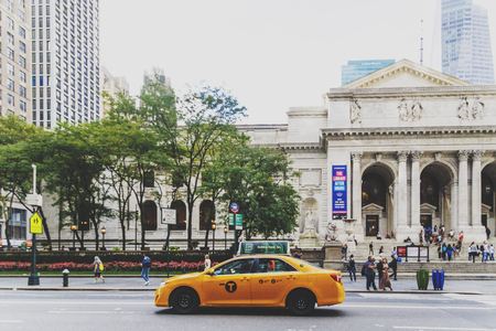 NEW YORK, NY - September 9th, 2017: yellow cab passying by in front of the Bryant Park and the New York Public Libraryのeditorial素材
