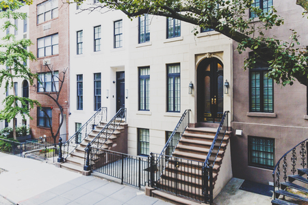 NEW YORK, NY - September 4th, 2017: Beautiful residentail street in Manhattan featuring house with...