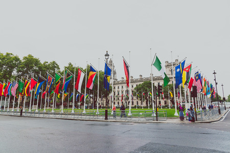 LONDON, UNITED KINGDOM - August, 13th, 2015: square with flags outside of the Big Ben and...