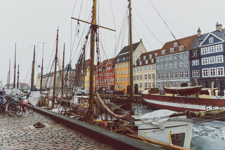 COPENHAGEN, DENMARK - March 11th, 2018: Copenhagen's famous Nyhavn harbour with the typical colorful houses and restaurants along the iced canals with traditional boatsのeditorial素材