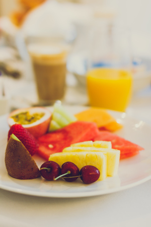 breakfast scene with fruit platter, latte coffee and orange juice in the backgroundの写真素材