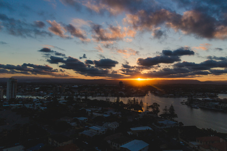 GOLD COAST, AUSTRALIA - January 16th, 2015: sun flare and tropical sunset over Surfers Paradise with mountain viewのeditorial素材