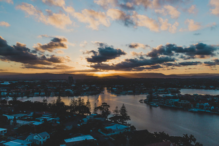 GOLD COAST, AUSTRALIA - January 16th, 2015: sun flare and tropical sunset over Surfers Paradise with mountain viewのeditorial素材