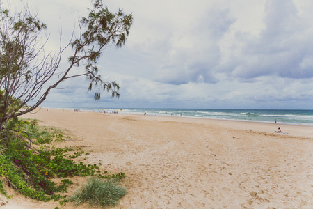 GOLD COAST, AUSTRALIA - January 5th, 2015: the beach in Surfers Paradise on an overcast day with golden sand and covered sky above the Pacific Oceanのeditorial素材