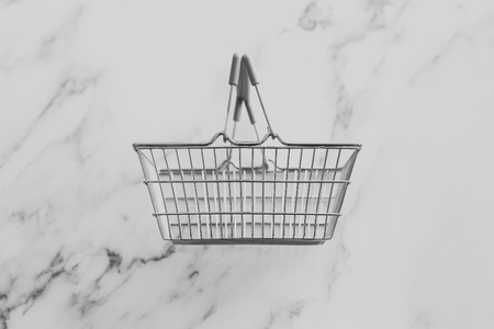 empty grocery store shopping basket isolated on marble surfaceの写真素材