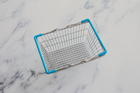 empty grocery store shopping basket isolated on marble surfaceの写真素材