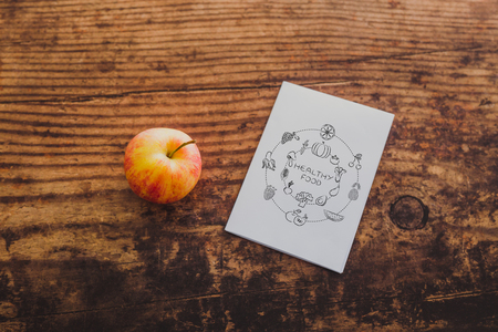 apple and healthy food note on memo paper on wooden table, concept of nutrition and dietの写真素材