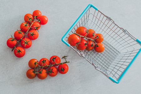 fresh tomatoes and shopping basket, concept of buying healthy foodの写真素材