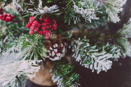 detail of small Christmas tree with snow mistletoe and pine cone decorations, cozy festive winter holidays feelingの写真素材