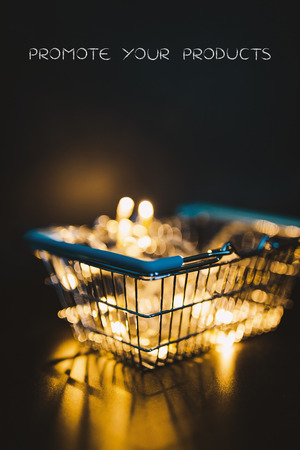 shining shopping cart with fairy lights bokeh inside shot at shallow depth of field, metaphor of selling and promoting your best productsの写真素材