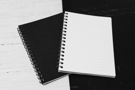 black and white notepads on opposite coor surface facing each other, contrasty minimalist flatlayの写真素材