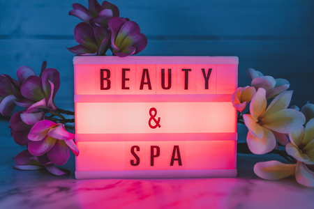 beauty and spa lightbox text surrounded by tropical frangipani monoi flowersの写真素材