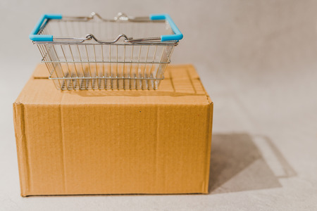 delivery parcel box with shopping basket, concept of online purchases and shippingの写真素材