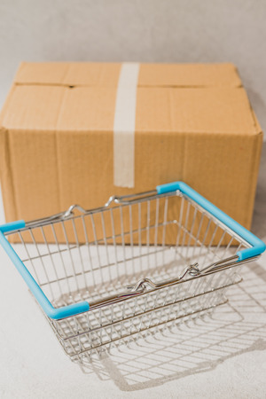 delivery parcel box with shopping basket, concept of online purchases and shipping