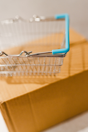 delivery parcel box with shopping basket, concept of online purchases and shippingの写真素材