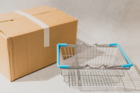 delivery parcel box with shopping basket, concept of online purchases and shippingの写真素材