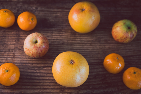 healthy fruit including oranges grapefruit and apples on dark wooden surface, concept of healthy nutritionの写真素材