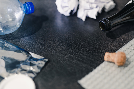 copyspace surrounded by reusable waste materials like plastic paper and glass with grabage bin, concept of reducing damage to the environmentの写真素材