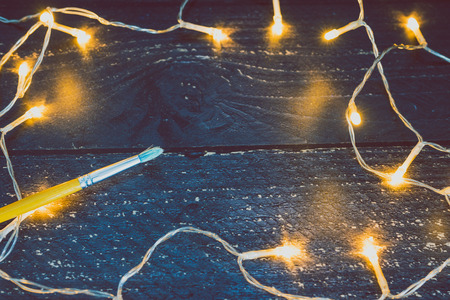brush on wooden desk with copyspace to add your text surrounded by fairy lights, concept of sharing a messageの写真素材