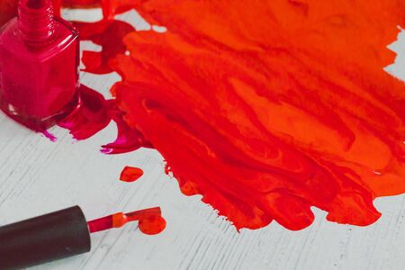 spilled nail polish colors mixed together with bottle and brush next to them, close-up shotの写真素材