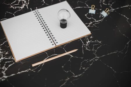 idea lightbulb and empty notebook to write goals and plans, concept of potential and achievements