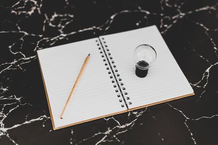 idea lightbulb and empty notebook to write goals and plans, concept of potential and achievements