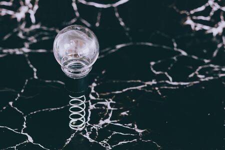 idea lightbulb popping up on spring with black marble background, concept of potential and goalsの写真素材