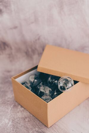 think outside the box concept: open box with miniature lightbulb going out of it